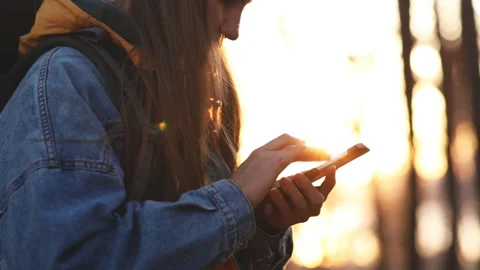 Female hands with a smartphone in the beautiful rays of sunset light. Stock Footage 127178561