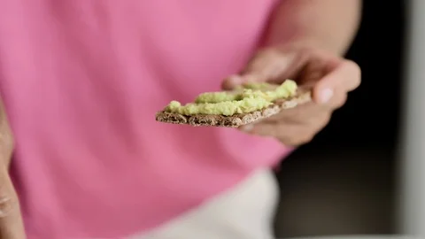 Female hands smear a green paste with a knife on the toast, close-up Stock Footage 115089749