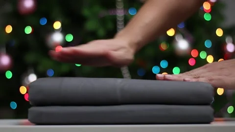 Female hands smoothing a stack of folded bedsheets Stock Footage 143269411