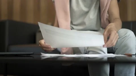 Female hands sorting out blanks, papers, documents sitting on a sofa Video stock 137469156