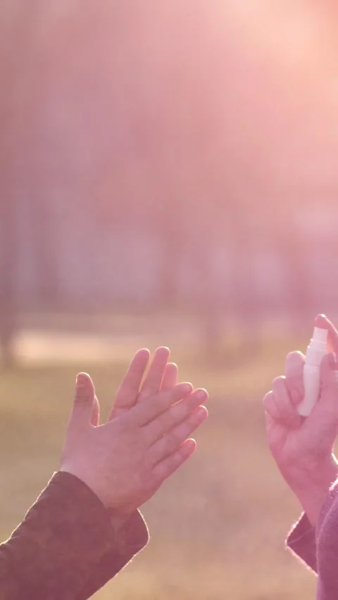 Female hands spraying disinfectant solution on child's hands. Health and safety Stock Footage 302386670