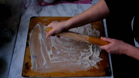 Female hands sprinkle flour on a pie board Stock Footage 154739765