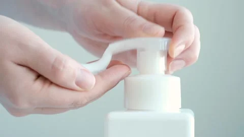 Female hands squeeze liquid soap with foam from white bottle. Stock Footage 303462896