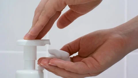 Female hands squeeze liquid soap with foam from white bottle. Stock Footage 311564502