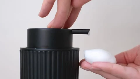 Female hands squeeze liquid soap with foam from black bottle. Stock Footage 321119816