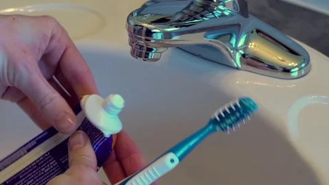 Female hands squeeze a small drop of toothpaste from an empty tube. Stock Footage 69944929