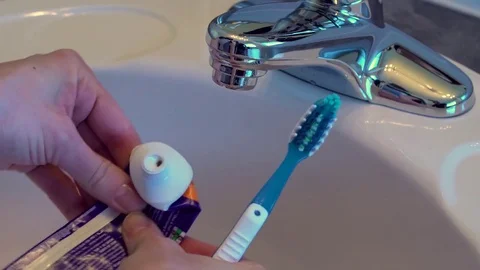Female hands squeeze a small drop of toothpaste from an empty tube. Stock Footage 69945007