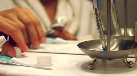 Female hands squeeze the toothpaste on the brush in bathroom Stock Footage 53291760
