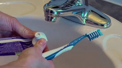 Female hands squeezing a toothpaste tube and getting almost nothing out. Stock Footage 69969464