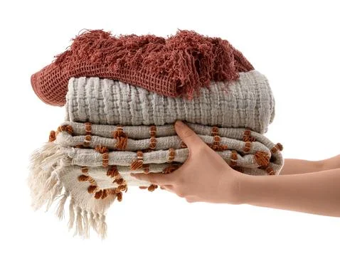Female hands with stack of blankets isolated on white background Stock Photos