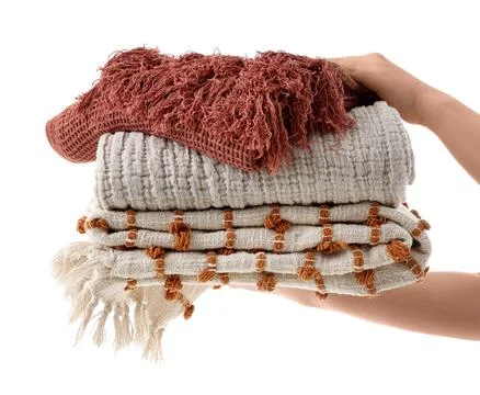 Female hands with stack of blankets isolated on white background Stock Photos