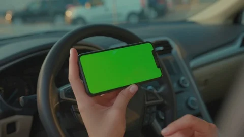 Female hands on steering wheel browsing mobile app of mock-up vertical Stock Footage 117548450