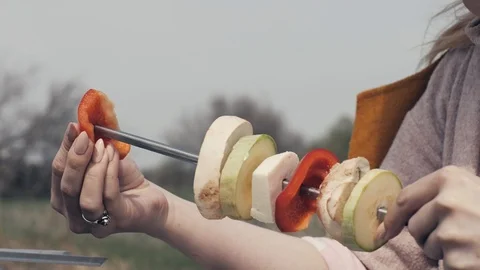 Female hands stringing vegetable on skewer in barbecue for picnic outdoor Stock Footage 91357870