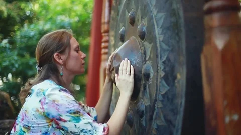 Female hands stroking the religious gong in Buddhist temple for good luck Stock Footage