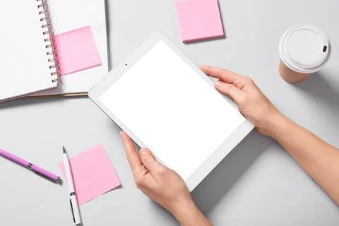 Female hands with tablet computer, takeaway cup of coffee, notebooks and stic Stock Photos
