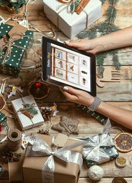 Female hands with tablet on table with hand made christmas decor Fotos Stock