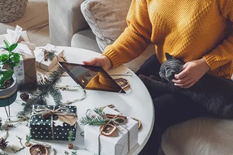Female hands with tablet on table with hand made christmas decor Foto stock