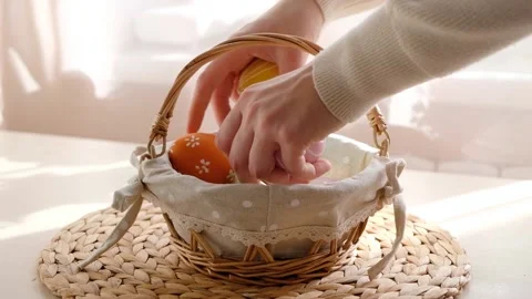 Female hands take Easter colorful eggs from basket on white wooden table. Happy Stock Footage 150767327