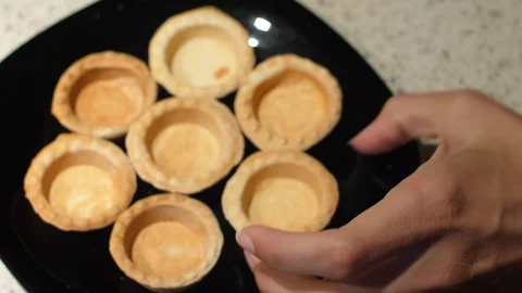 Female hands take empty tartlets from a plate and fill them with cottage cheese Stock Footage 119403580