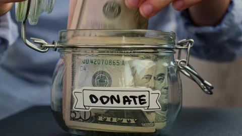 Female hands take money from Saving Money In Glass Jar filled with Dollars Stock Footage 261646542