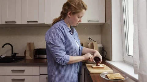 Female hands take out raspberry jelly from a jar, mother makes a sandwich t.. Stock Footage 253575926