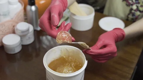Female hands take a paste for shugaring. In slow motion Stock Footage 124498485