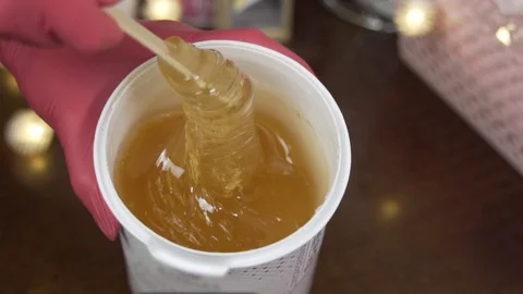 Female hands take a paste for shugaring. in slow motion, 100 frames Stock Footage 124498531