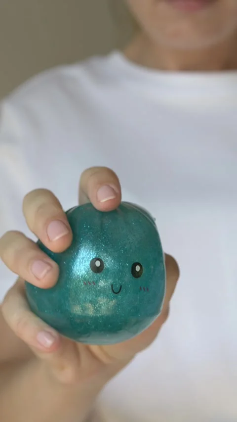 Female hands taking blue glitter squishy bun toy out of mystery package and 動画素材 345653327