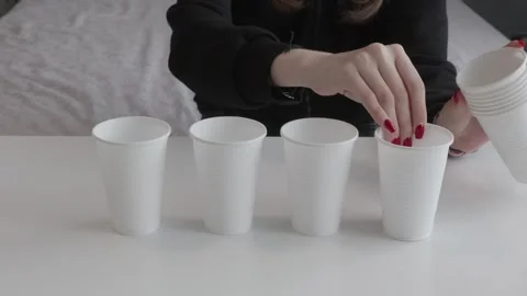 Female hands taking white plastic cups from stack and arranging on white table Video stock 319816345