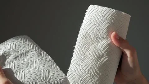 Female hands tear off piece of white paper towel from a roll Stock Photos