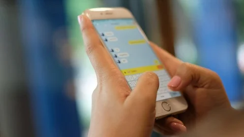 Female hands texting or typing on a touchscreen smartphone Stock Footage 76032914