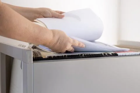Female hands through folders In Document Storage close-up, Home Archive, Re.. Stock Photos