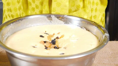 Female hands throwing a handful of multi-colored raisins into a dish with dough Stock Footage 153480166