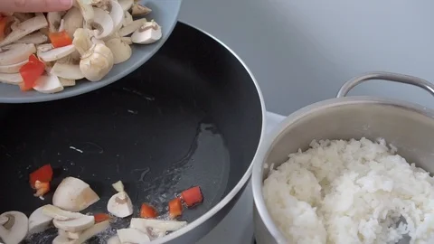 Female hands throws vegetables into the pan for frying 動画素材 111956678