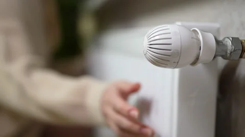 Female hands touch the cold radiator of the battery and open the valve to escape Stock Footage 166535544