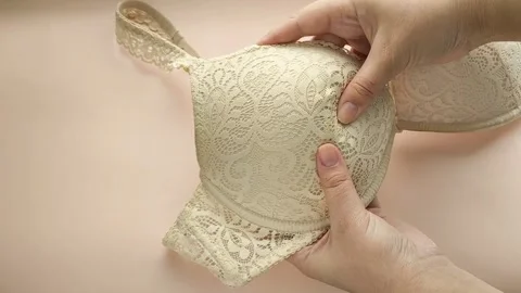 Female hands touch the soft push-up of a womans bust. Womens Underwear Stock Footage 325291442