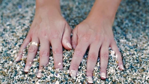 Female hands touching beach pebbles, close-up Stock Footage