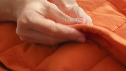Female hands touching groping material orange waterproof fabric of winter jacket Stock Footage 220660396