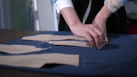 Female hands tracing pattern on cloth in workshop Stock Footage 108117903