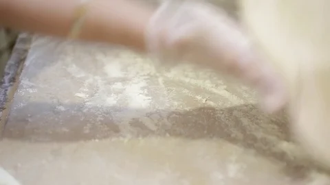 Female hands in transparent gloves roll out a round large tortilla on the table Video stock 102709289
