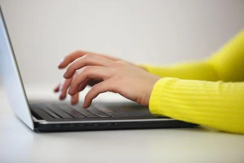 Female hands typing code on a modern laptop computer behind a desk Stock Photos