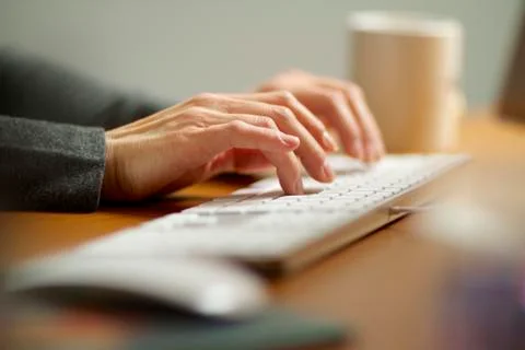Female hands typing on a computer keyboard working in her office. 写真素材