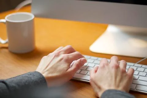 Female hands typing on a computer keyboard working in her office. 写真素材