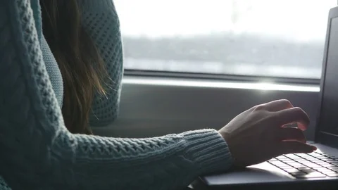 Female hands typing on keyboard of laptop in train. Woman chatting with friends Stock Footage