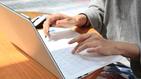 Female hands typing on laptop computer keyboard against bright background Stock Footage 64685059