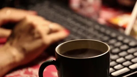 Female hands typing on a PC keyboard and cup of hot coffee at night with smoke Stock Footage 81920132