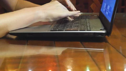 Female hands typing text on notebook keyboard in cafe at evening. Arms of young Stock Footage 335271412