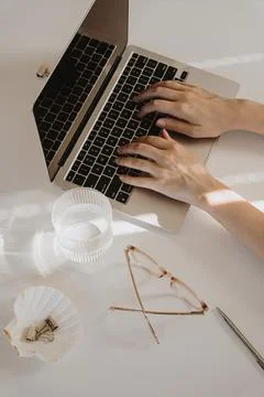 Female hands typing using laptop computer. Home office desk table workspace.  스톡 사진