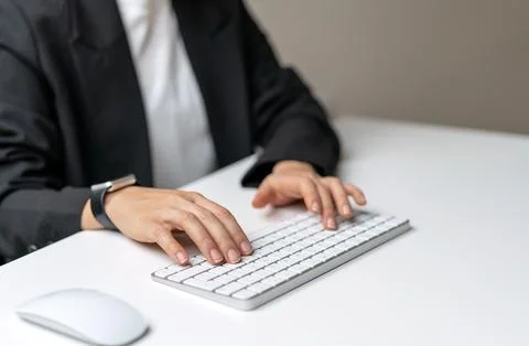 Female hands typing on wireless computer keyboard. Stock Photos