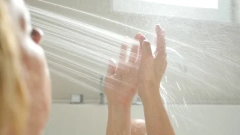 Female hands under streams of water from the shower. moistening of hands. 4k Stock Footage 82525038